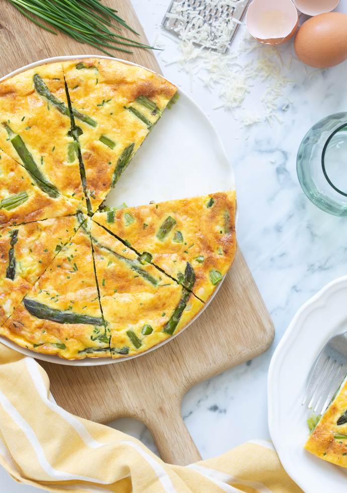 asparagus frittata cut into slices and served on a plate.