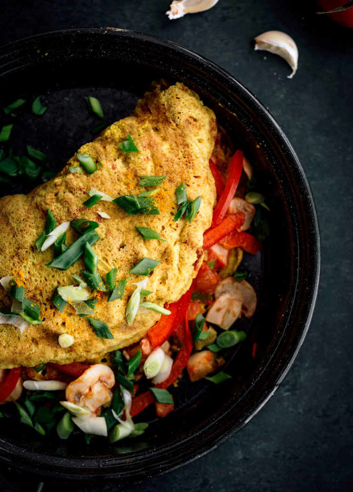 chickpea omelette stuffed with mushrooms and red pepper, topped with chopped spring onion.