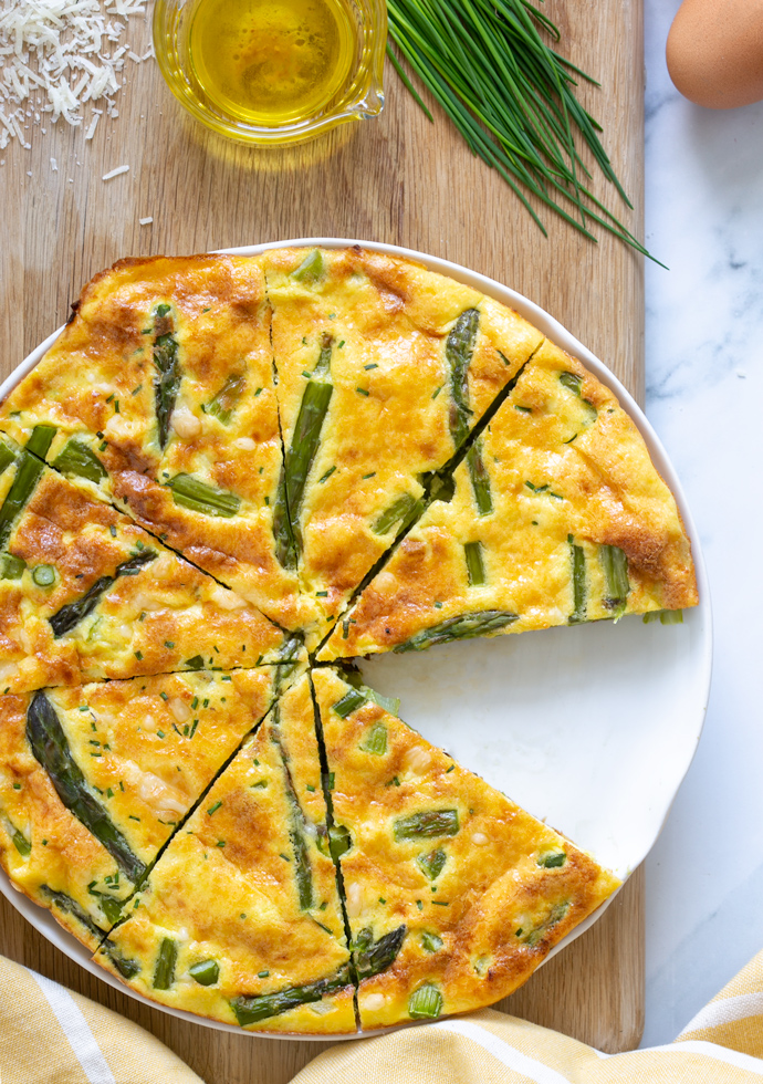 asparagus frittata cut into slices and served on a plate.