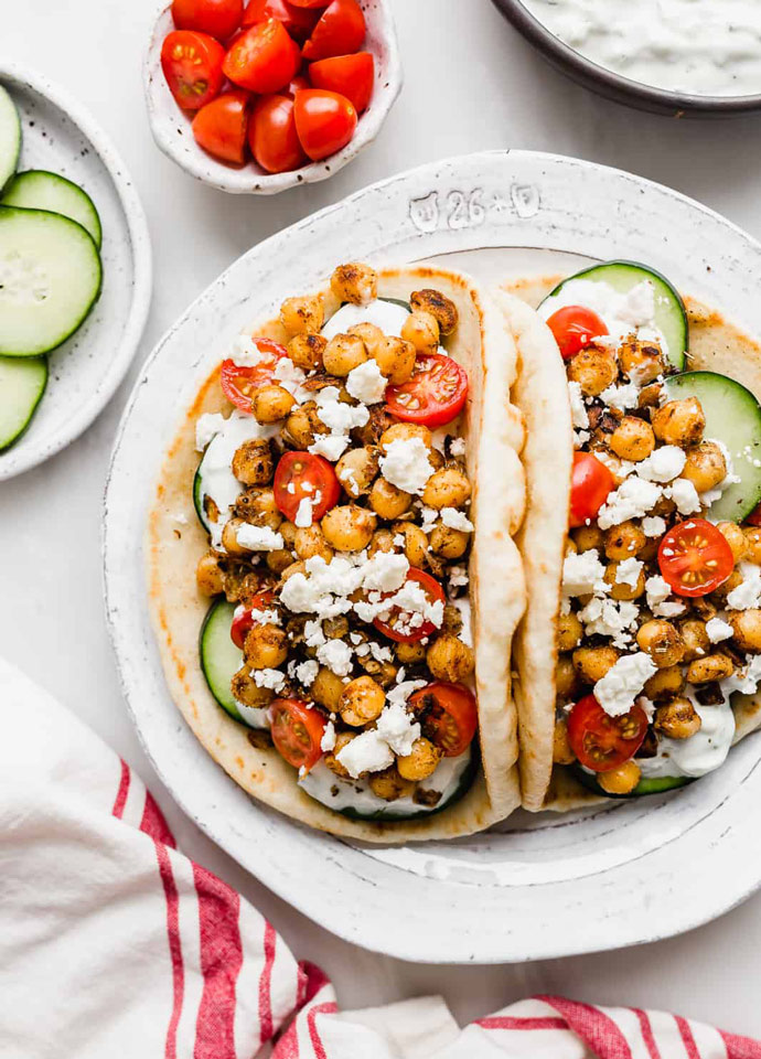 two pita bread stuffed with chickpeas and veggies gyros-style. 