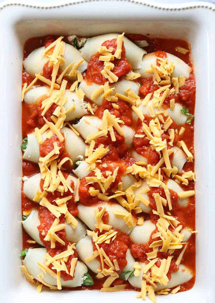 vegan stuffed shells topped with tomato sauce and vegan cheese.