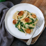 vegan scallops with pasta and sauteed spinach.