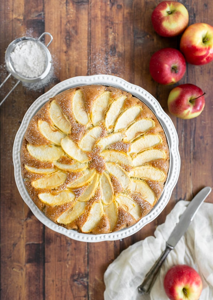 torta di mele topped with sliced apples and confectioner's sugar.