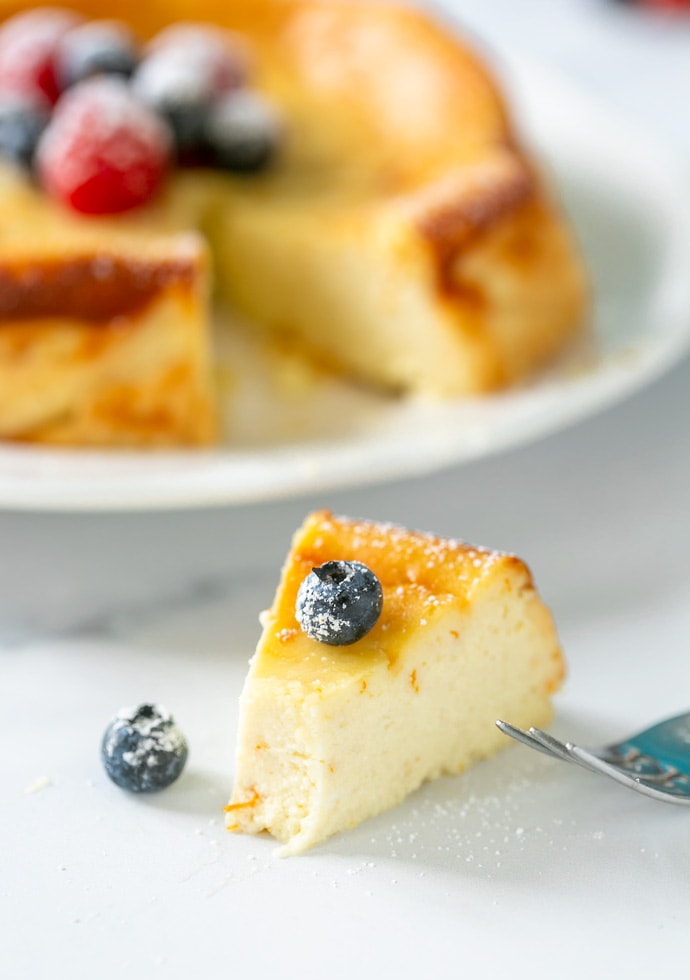 slice of ricotta cheesecake, topped with a blueberry.