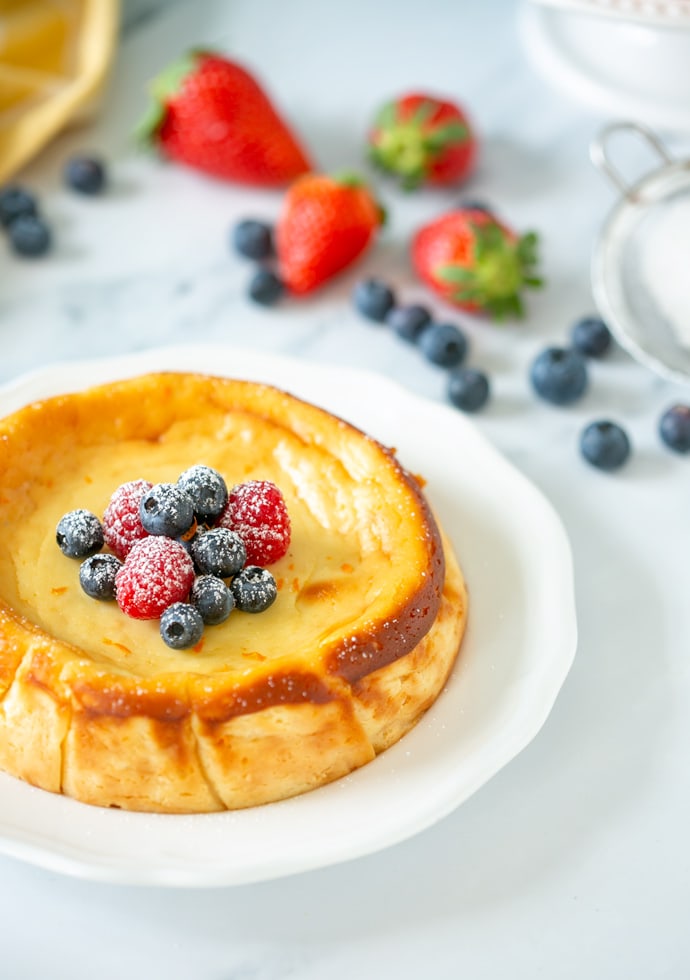 Italian ricotta cheesecake topped with fresh berries and confectioner's sugar.