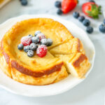 Italian ricotta cheesecake topped with fresh berries and confectioner's sugar.