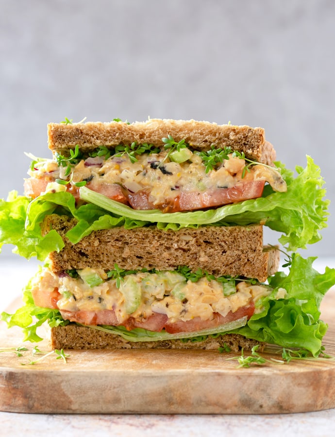 vegan chickpea salad sandwich on a chopping borad.