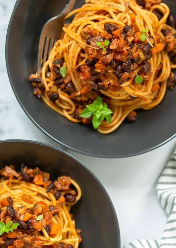 vegan spaghetti bolognese divided among two bowls.