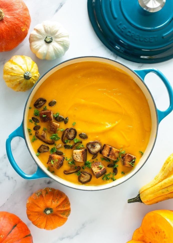 creamy vegan pumpkin soup and white beans topped with croutons and sauteed mushrooms.