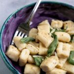 homemade ricotta gnocchi served with butter and sage. Image with text for Pinterest.