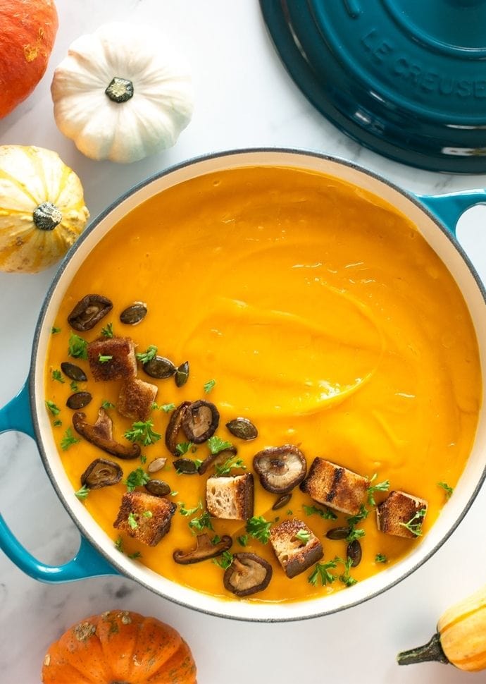 creamy vegan pumpkin soup and white beans topped with croutons and sauteed mushrooms.