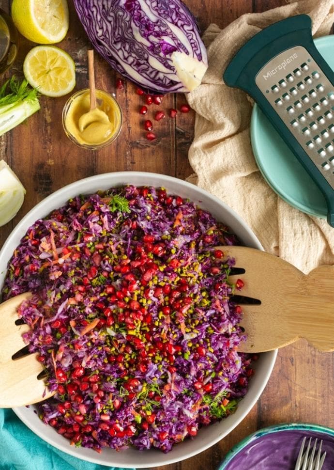 slaw topped with pistachio nuts and pomegranate seeds.