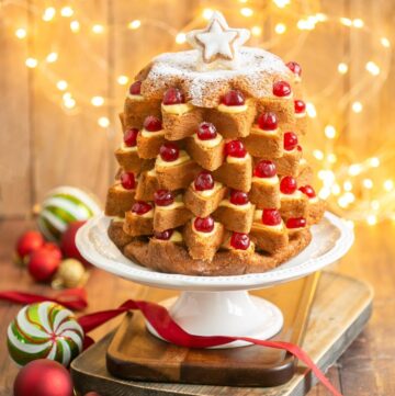 Pandoro Italian Christmas cake filled with pastry cream and topped with candied cherries.