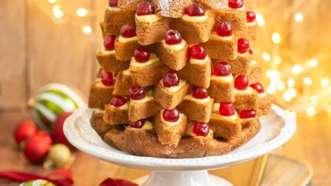 Pandoro Italian Christmas cake filled with pastry cream and topped with candied cherries.