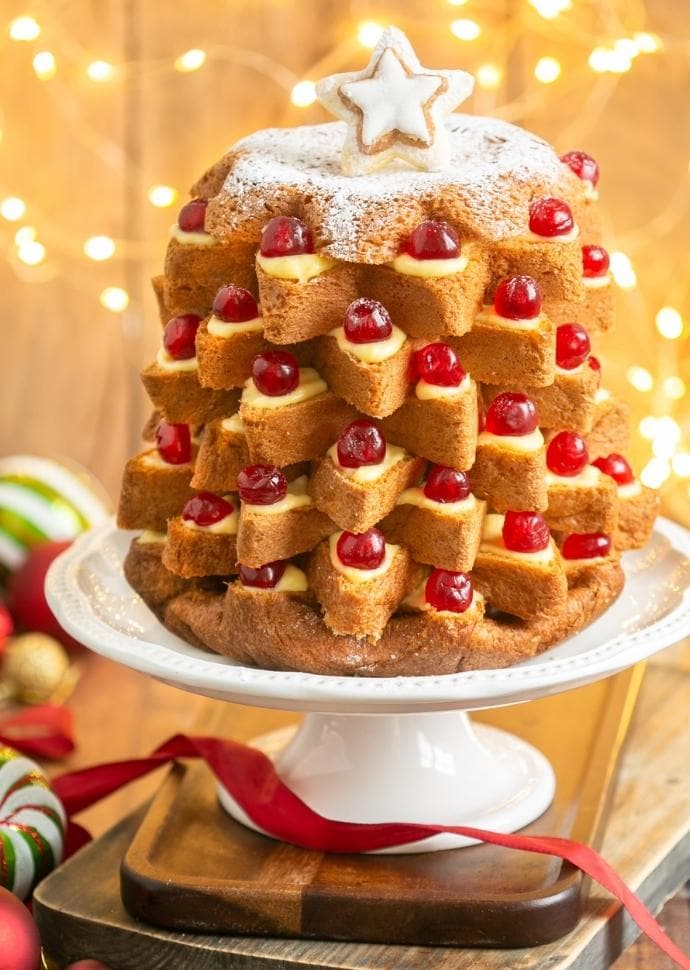 Pandoro Italian Christmas cake filled with pastry cream and topped with candied cherries.