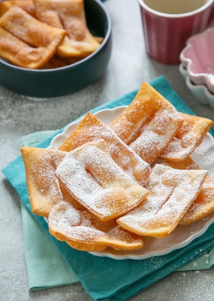 Chiacchiere topped with confectioner's sugar.