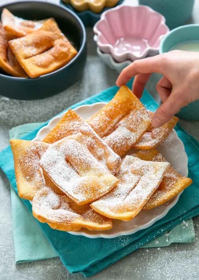 chiacchiere topped with confectioner's sugar.