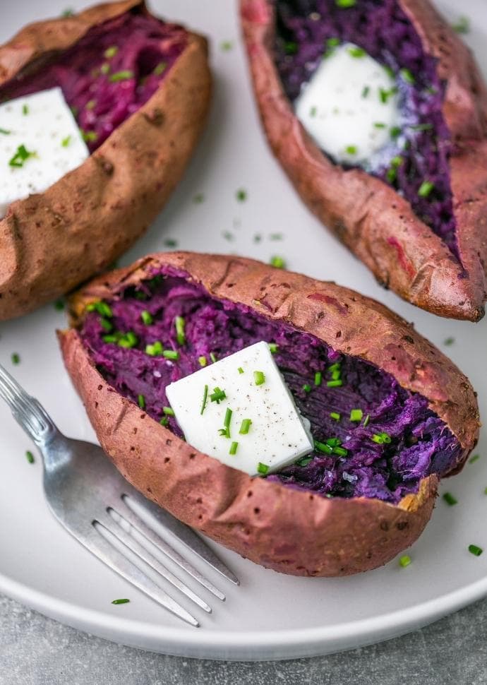 roasted purple sweet potato served with butter and chives on top.