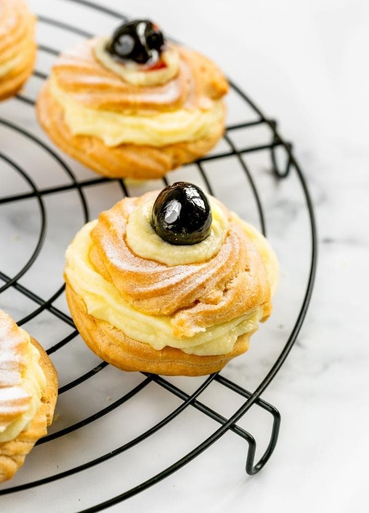 st joseph zeppole filled with pastry cream and topped with black cherry.