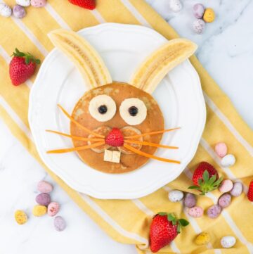 Easter bunny pancake decorated with bananas, strawberry, blueberries and carrot.