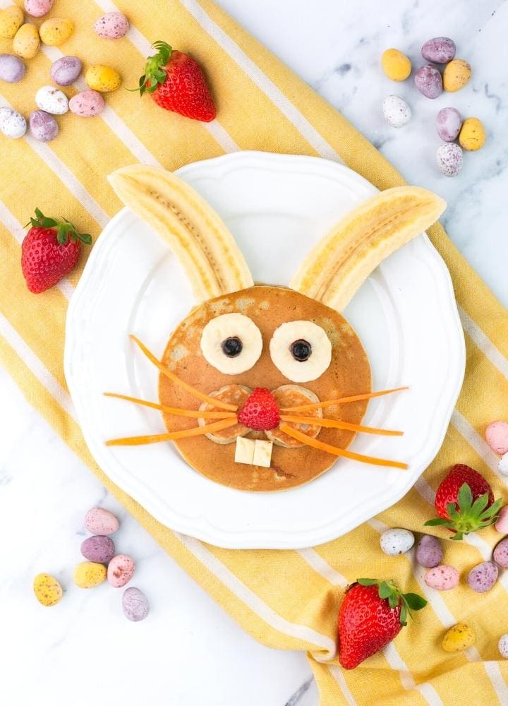 Bunny pancakes decorated with bananas, strawberry, blueberries and carrot.