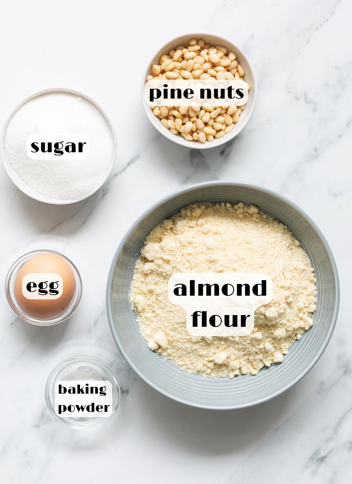 Pignoli cookies ingredients: almond flour, egg, baking powder, sugar, pine nuts.