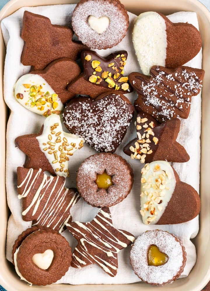 chocolate italian cookies decorated with white and dark chocolate, nuts and sprinkles.