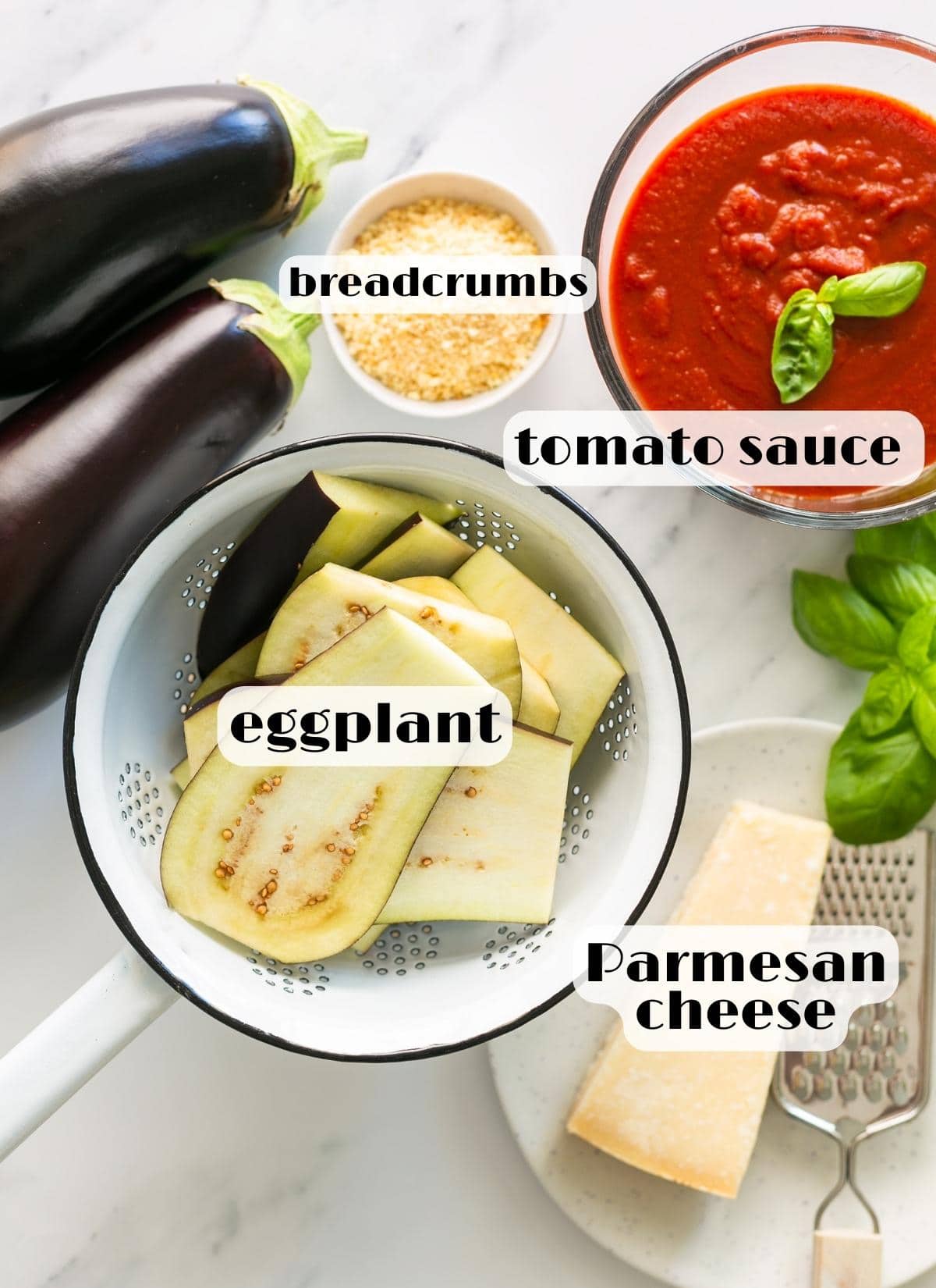 Parmigiana di melanzane ingredients: eggplant, tomato sauce, parmesan cheese, basil leaves, breadcrumbs.