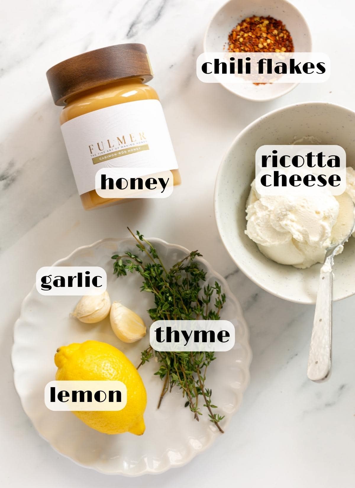 whipped ricotta recipe ingredients: ricotta cheese, honey, thyme, chili flakes, garlic, lemon.