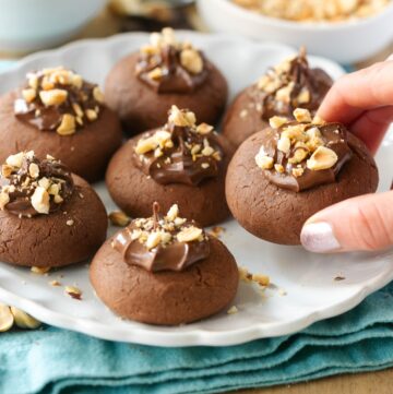 nutella thumbprint cookies topped with hazelnuts.