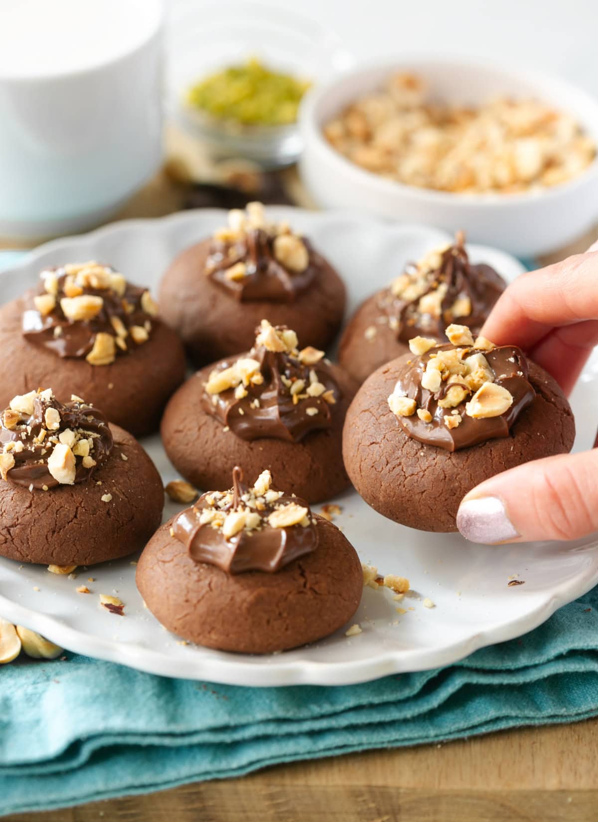 Nutella thumbprint cookies topped with chocolate spread and hazelnuts.