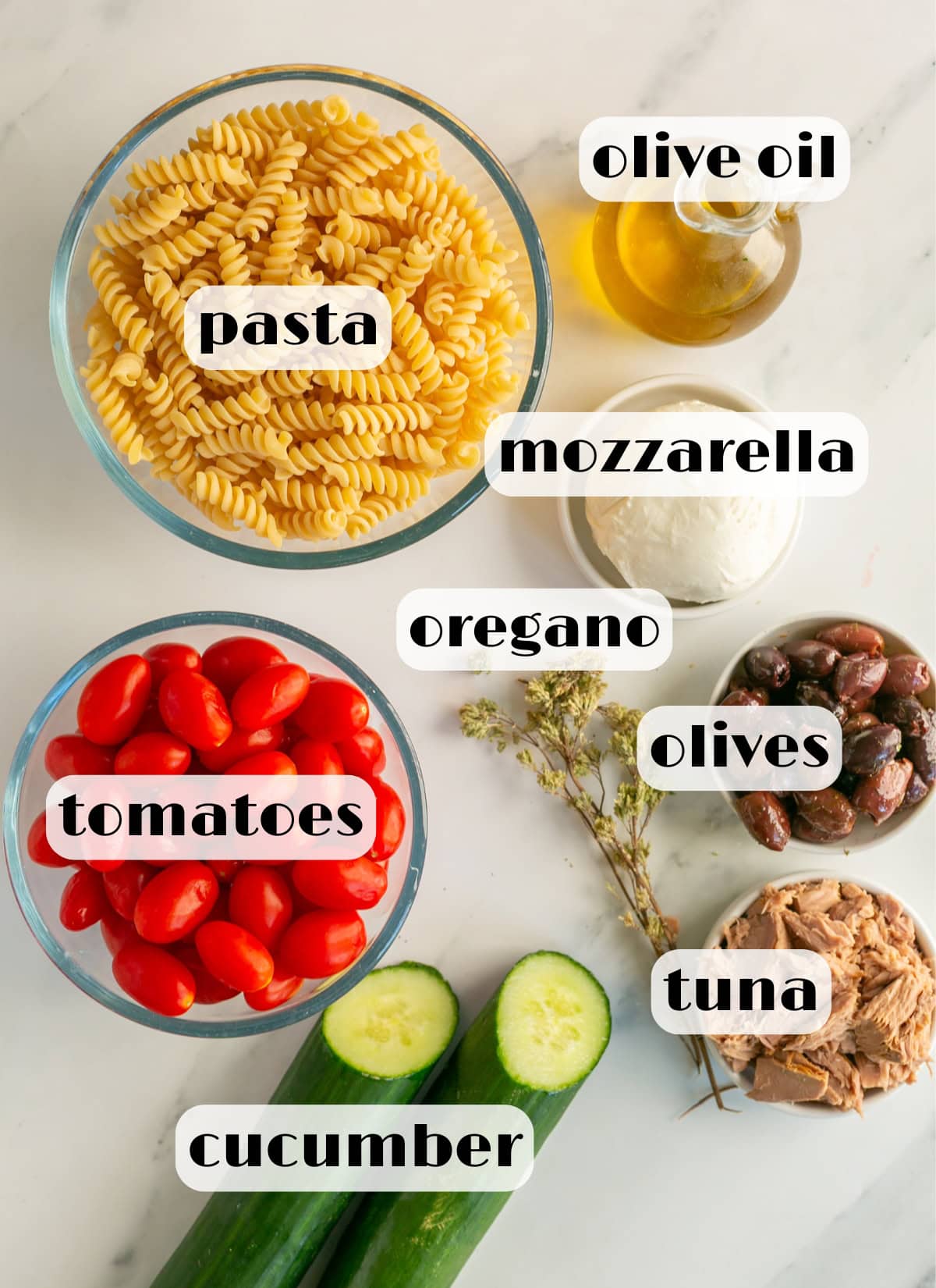 italian tuna pasta salad ingredients: pasta, canned tuna, cucumber, tomatoes, olive oil, mozzarella, oregano, olives.
