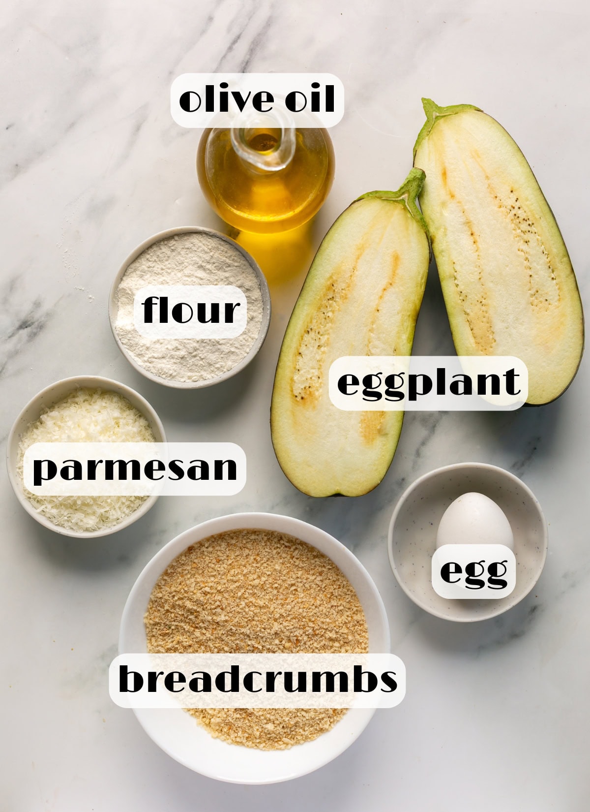 Ingredients for eggplant cutlets including eggplant, flour, egg, breadcrumbs, Parmesan, and olive oil.