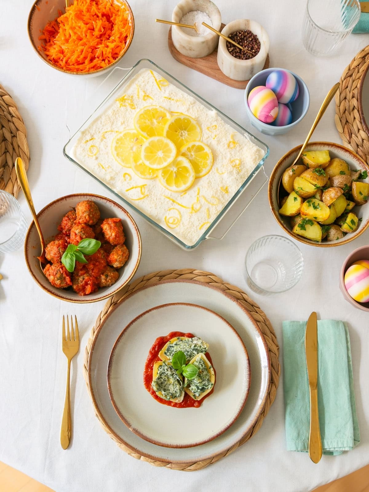 ricotta stuffed pasta shells, served on a set table with meatballs, roasted potatoes and limoncello tiramisu on the side.