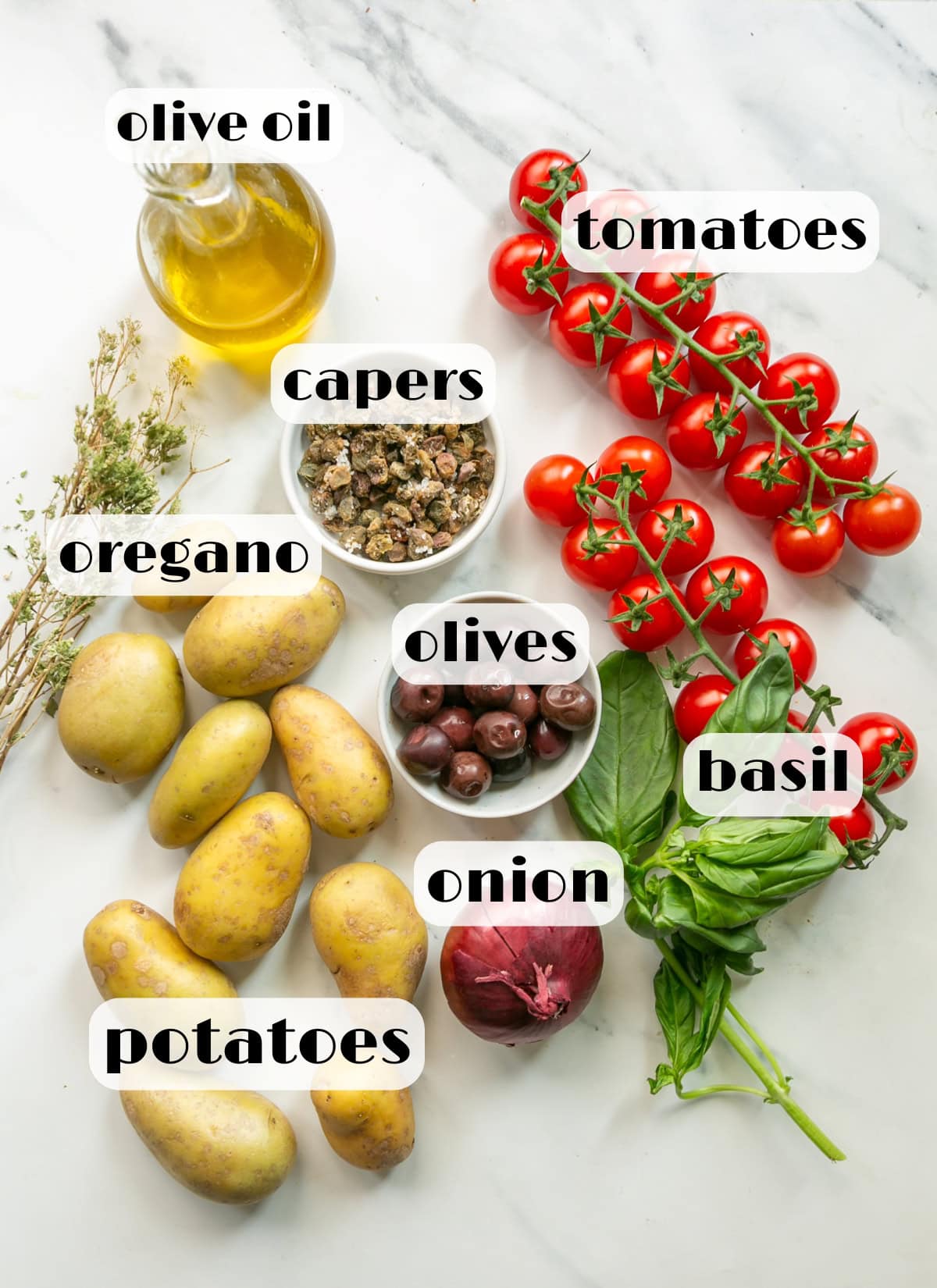 sicilian potato salad ingredients: potatoes, tomatoes, basil, olives, oregano, capers, onion, olive oil